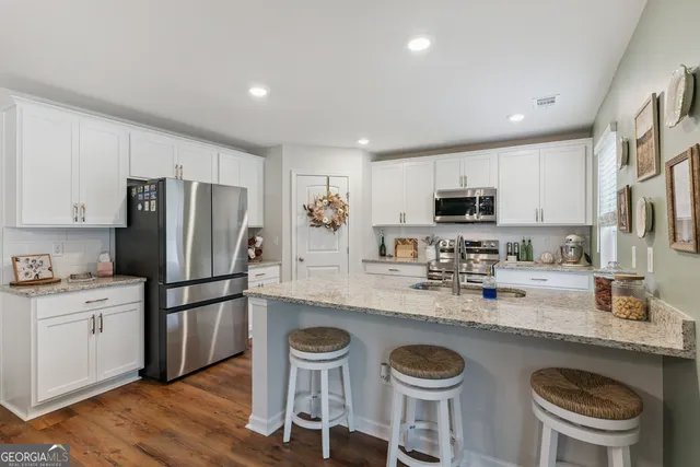 a kitchen with stainless steel appliances granite countertop a sink stove and cabinets