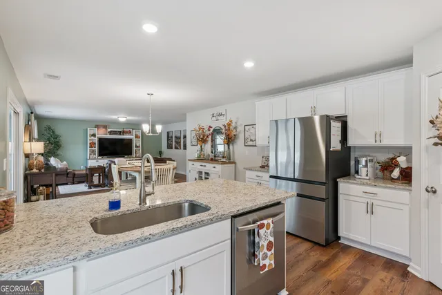 a kitchen with granite countertop a sink and a wooden floor