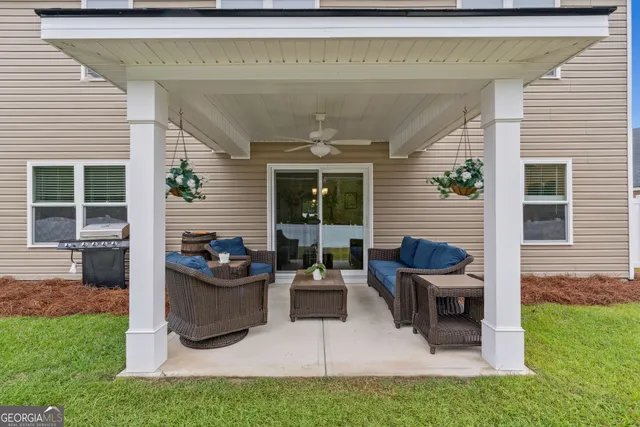 a view of a patio with table and chairs and a barbeque
