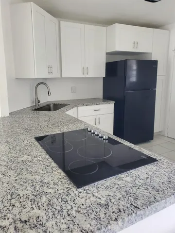a kitchen with stainless steel appliances granite countertop a sink and a stove