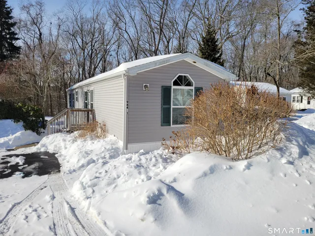 a front view of a house with a yard covered in snow