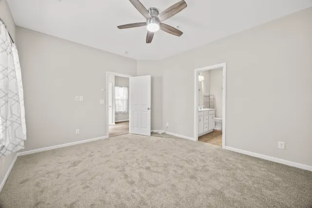 an empty room with closet and a ceiling fan