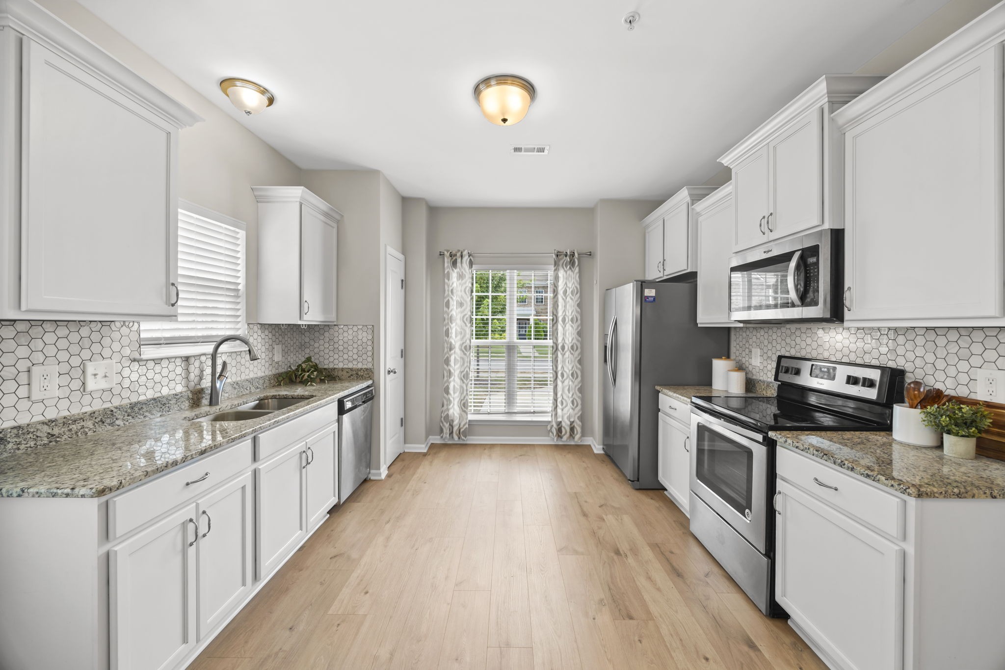 501 Shirebrook Circle Spring Hill, TN 37174 - Photo 3 of 26 a kitchen with granite countertop a stove top oven a sink a counter space and cabinets
