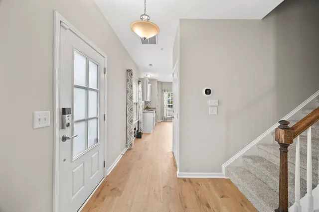 a view of a hallway with wooden floor and staircase