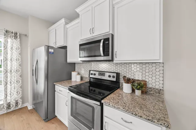 a kitchen with stainless steel appliances granite countertop a refrigerator stove and microwave
