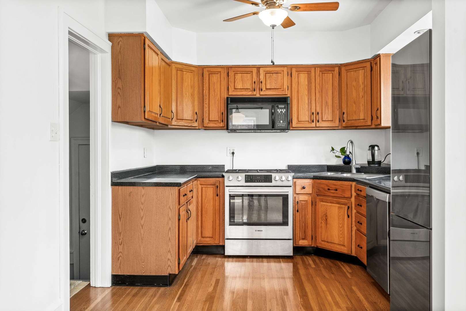 1302 Hillcrest Street Normal, IL 61761 - Photo 12 of 48 a kitchen with stainless steel appliances granite countertop wooden cabinets a sink a stove a refrigerator and island with wooden floor