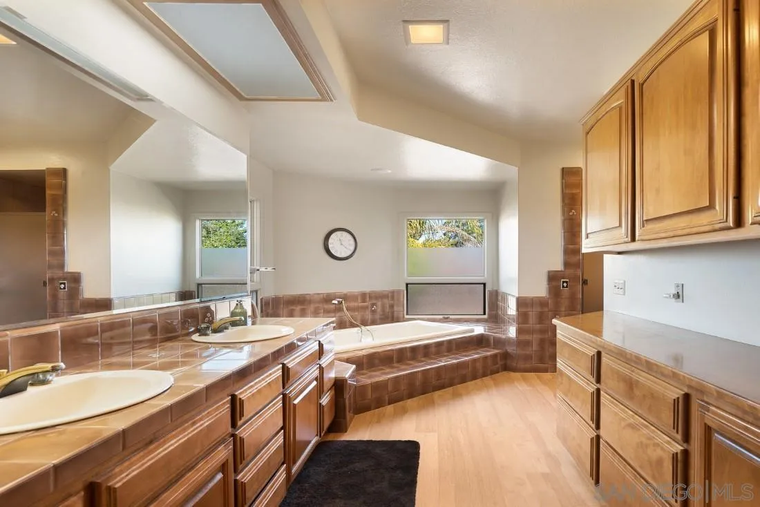 15938 Overview Road Poway, CA 92064 - Photo 32 of 72 a spacious bathroom with a double vanity sink and a mirror