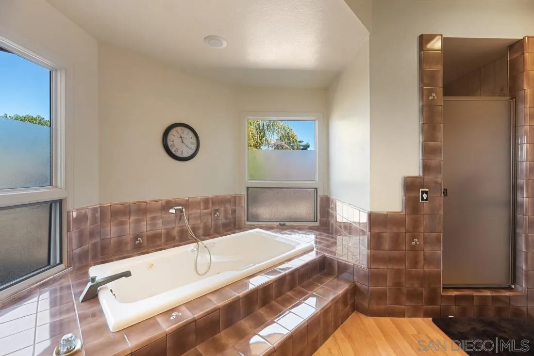 15938 Overview Road Poway, CA 92064 - Photo 33 of 72 a bathroom with a tub a sink and a large mirror