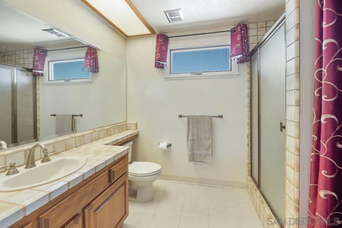 15938 Overview Road Poway, CA 92064 - Photo 60 of 72 a bathroom with a granite countertop toilet sink and mirror
