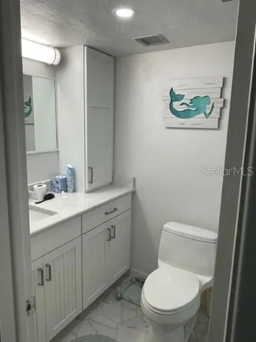a bathroom with a toilet a sink and mirror