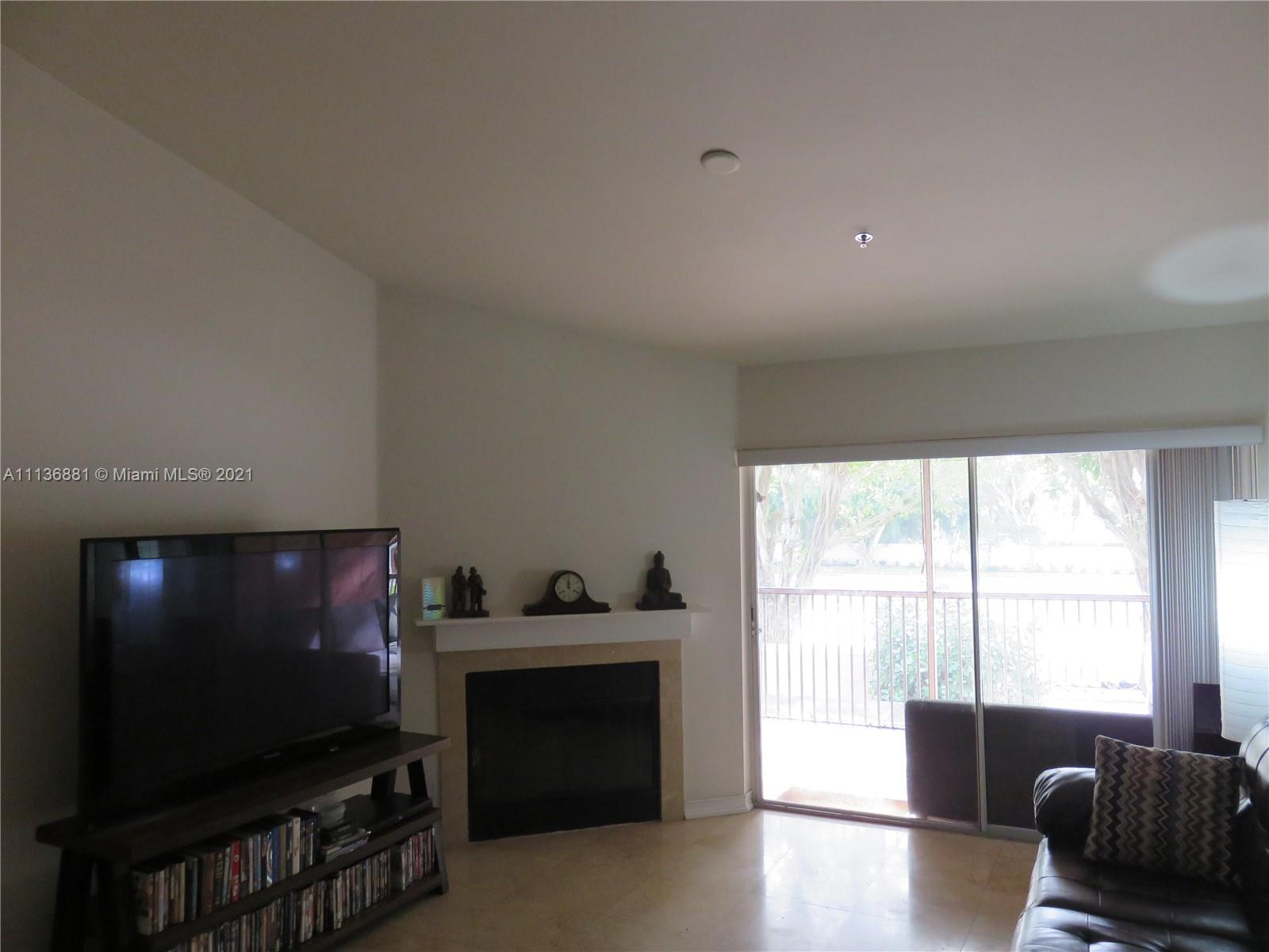 3237 Clint Moore Road, Unit 204 Boca Raton, FL 33496 - Photo 2 of 13 a living room with furniture and a flat screen tv