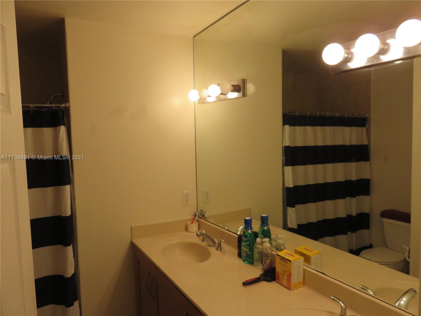 3237 Clint Moore Road, Unit 204 Boca Raton, FL 33496 - Photo 12 of 13 a bathroom with a sink and a mirror