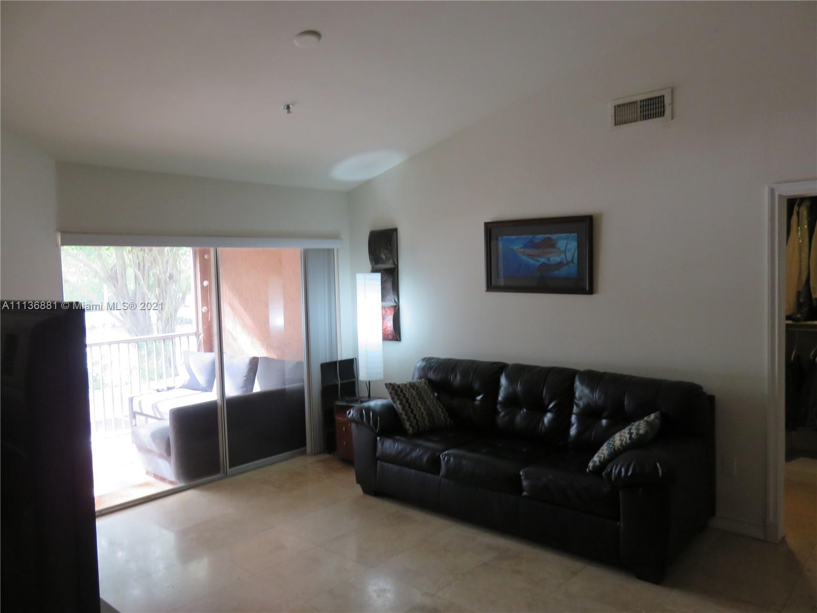 3237 Clint Moore Road, Unit 204 Boca Raton, FL 33496 - Photo 3 of 13 a living room with furniture a large window and a flat screen tv