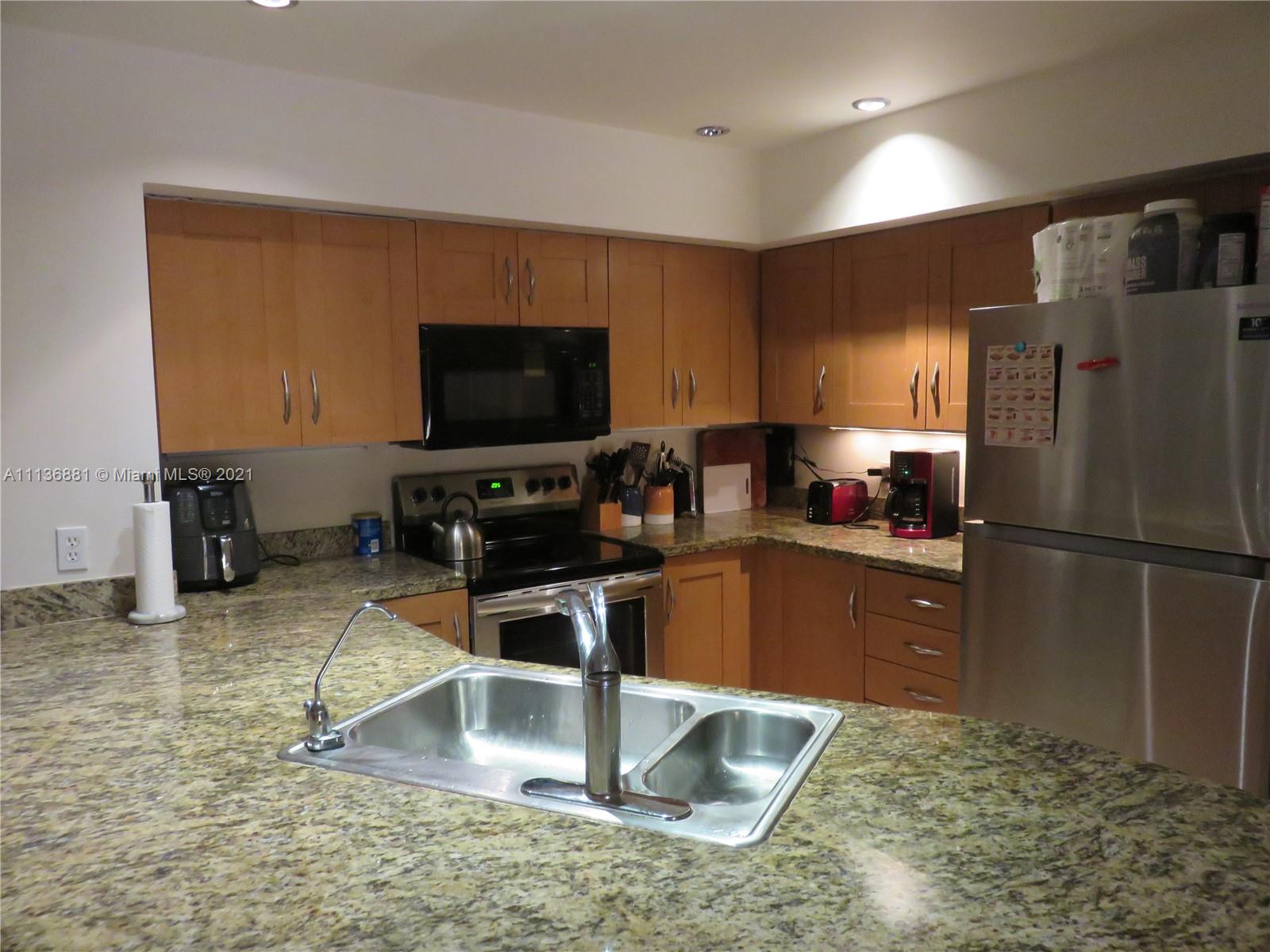 3237 Clint Moore Road, Unit 204 Boca Raton, FL 33496 - Photo 4 of 13 a kitchen with a refrigerator sink and cabinets