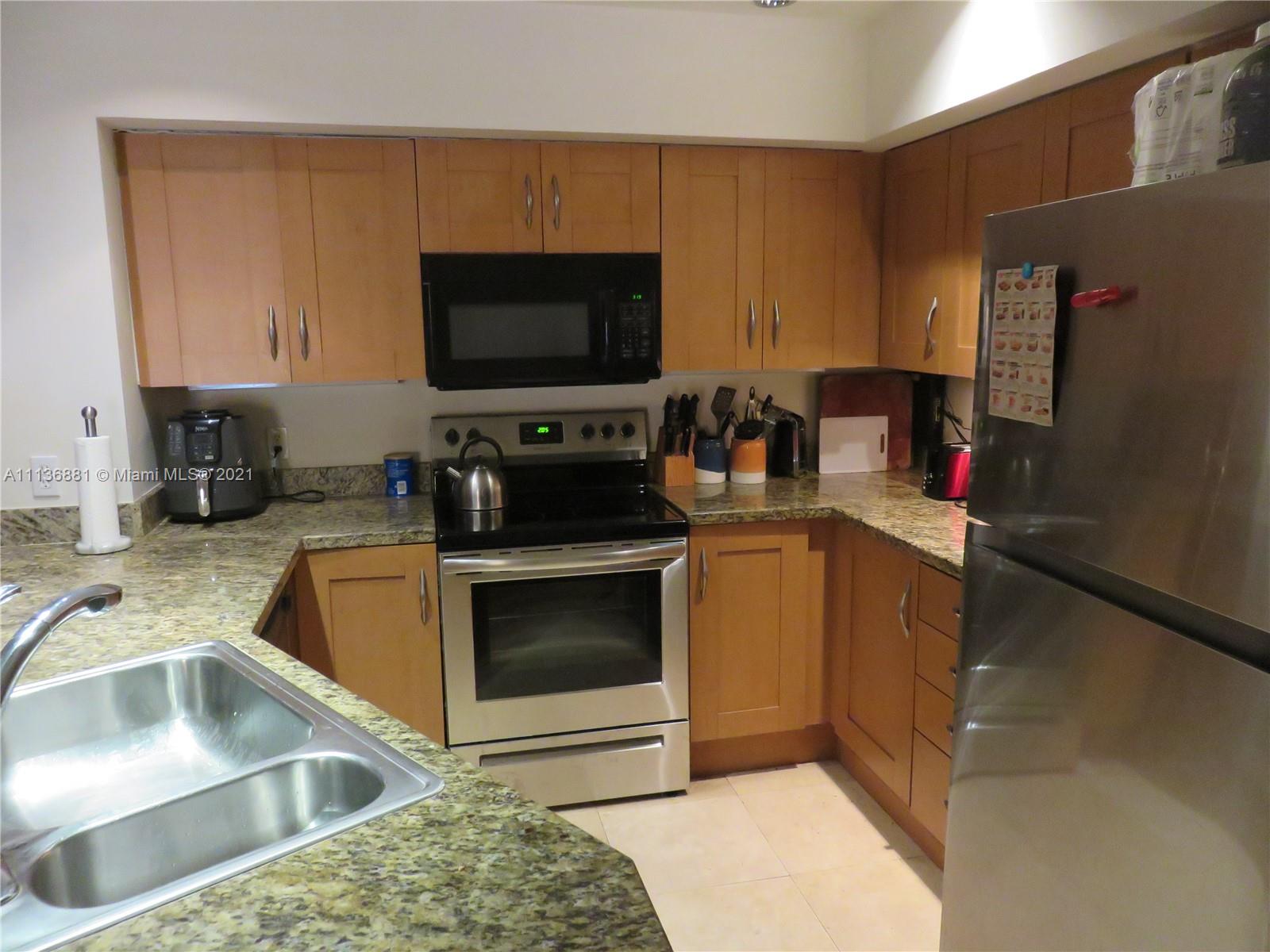 3237 Clint Moore Road, Unit 204 Boca Raton, FL 33496 - Photo 5 of 13 a kitchen with a sink stove and refrigerator