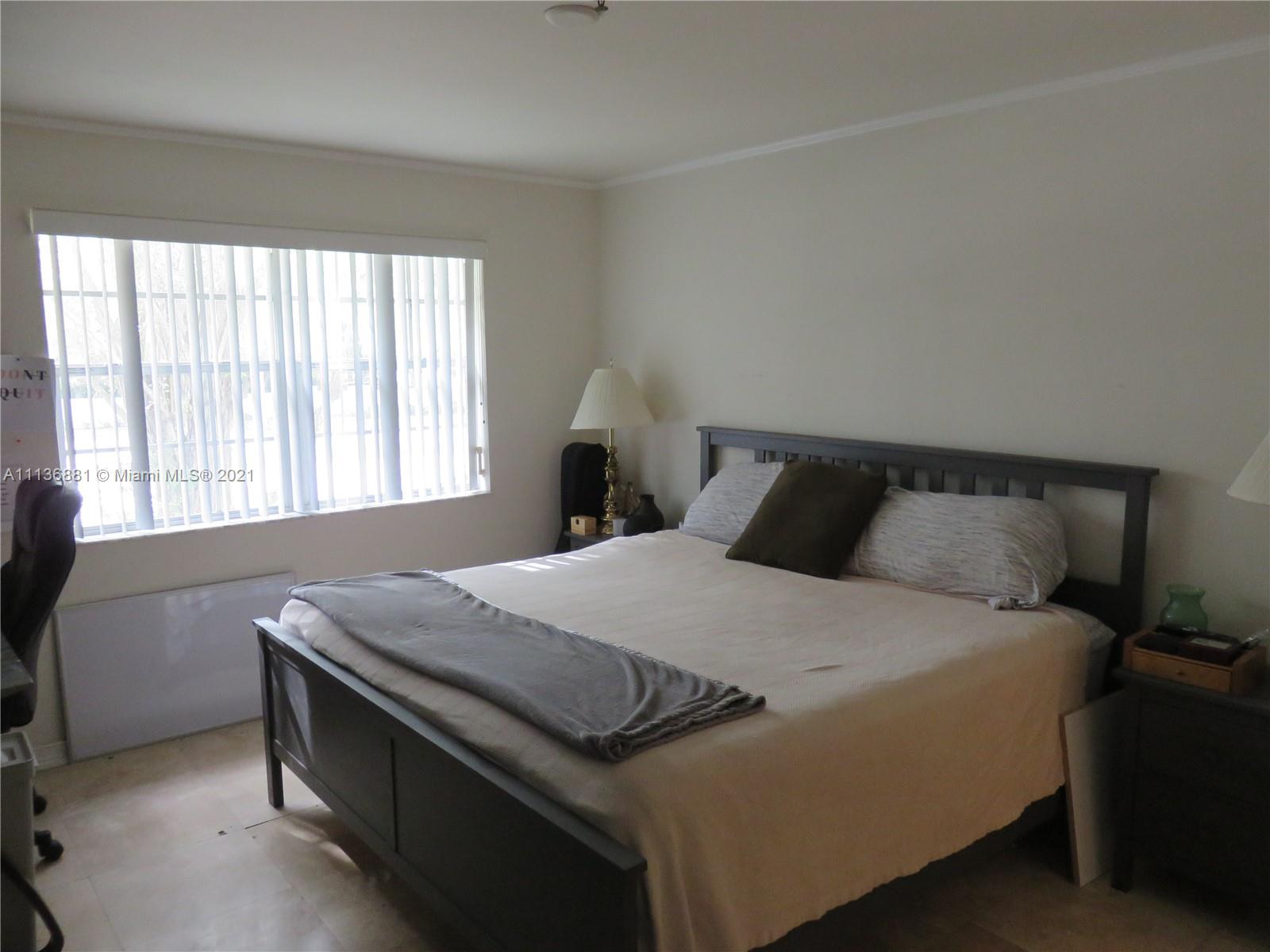 3237 Clint Moore Road, Unit 204 Boca Raton, FL 33496 - Photo 8 of 13 a bedroom with a bed and window