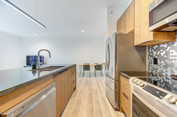 a kitchen with stainless steel appliances a sink a stove and a refrigerator