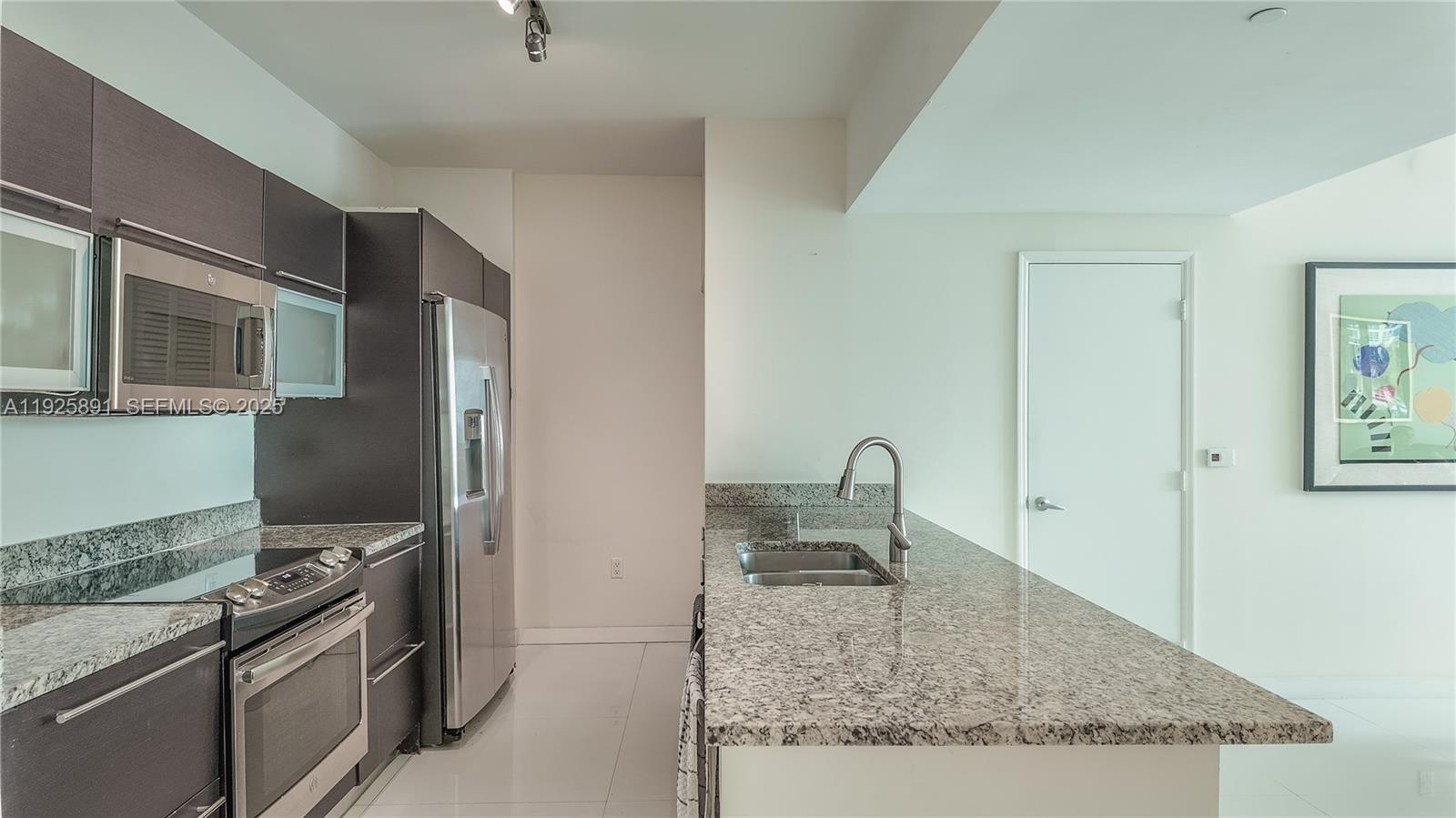 951 Brickell Avenue, Unit 1206 Miami, FL 33131 - Photo 6 of 12 a kitchen with stainless steel appliances granite countertop a sink stove and refrigerator