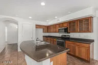 a kitchen with stainless steel appliances granite countertop a sink a stove and a refrigerator