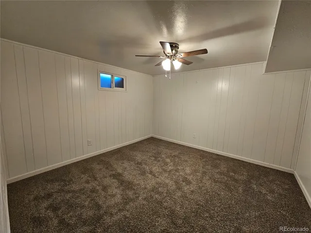 an empty room with a window and a ceiling fan