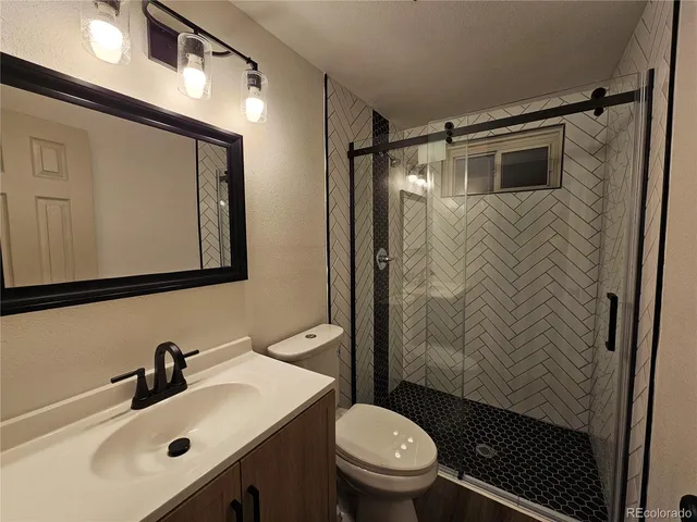 a bathroom with a sink toilet mirror and shower