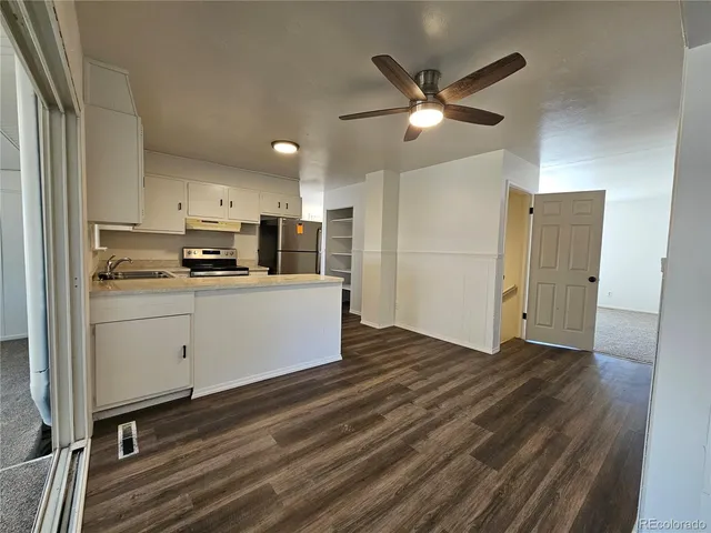 a kitchen with cabinets wooden floor and stainless steel appliances