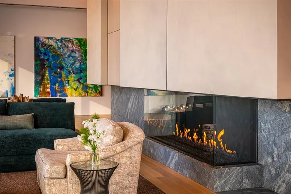 a view of a dining room with furniture one side kitchen view and wooden floor
