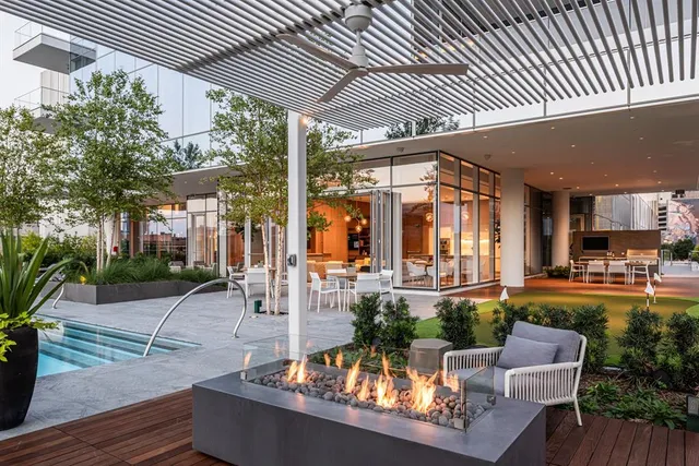 a view of a patio with couches table and chairs potted plants and a large tree