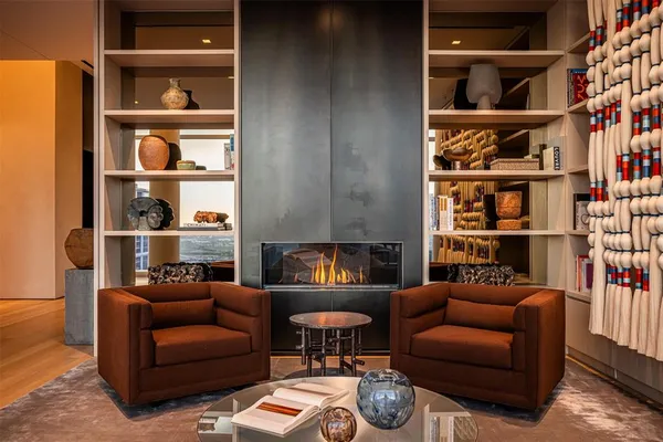 a living room with furniture a book shelf and a window