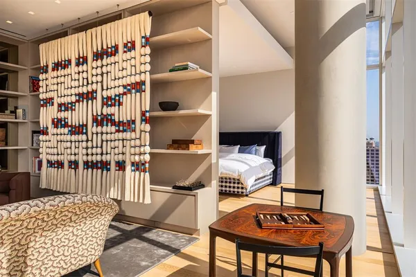 a living room with furniture a rug and a book shelf