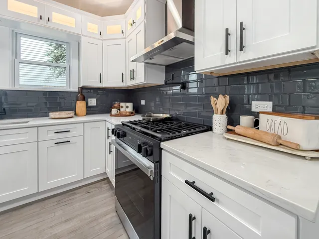 a kitchen with white cabinets and appliances