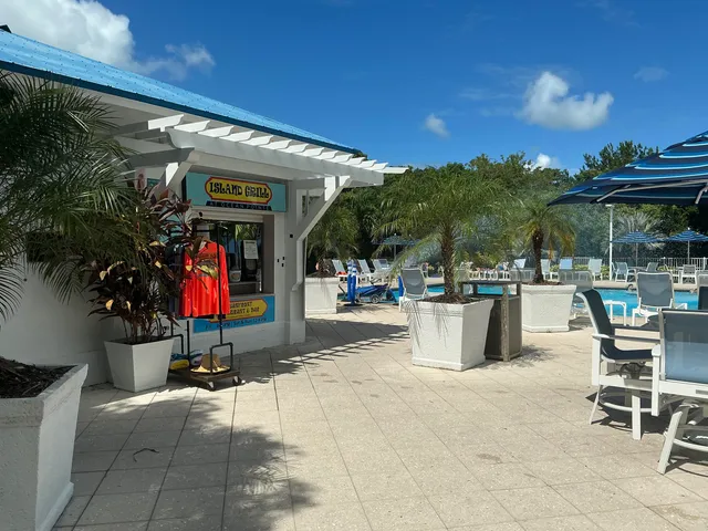 a view of a patio with dining table and chairs under an umbrella with a patio