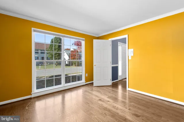 a kitchen with stainless steel appliances granite countertop a refrigerator a sink dishwasher a oven and a dining table with wooden floor