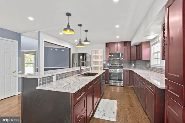 a kitchen with granite countertop a sink stove and cabinets