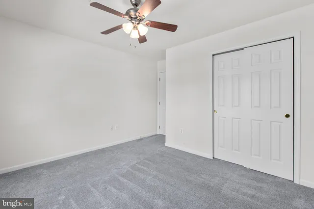 a view of an empty room with a ceiling fan