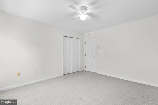 a view of an empty room with a ceiling fan