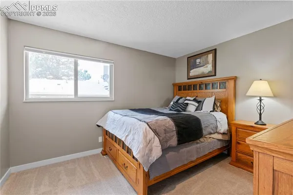 a bed sitting in a bedroom next to a window