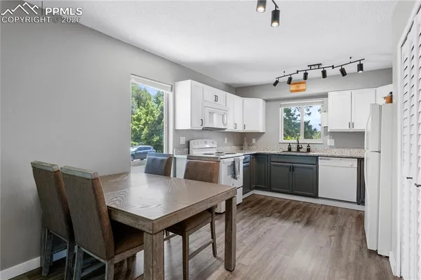 a kitchen with a refrigerator a stove a sink dishwasher with a dining table and chairs