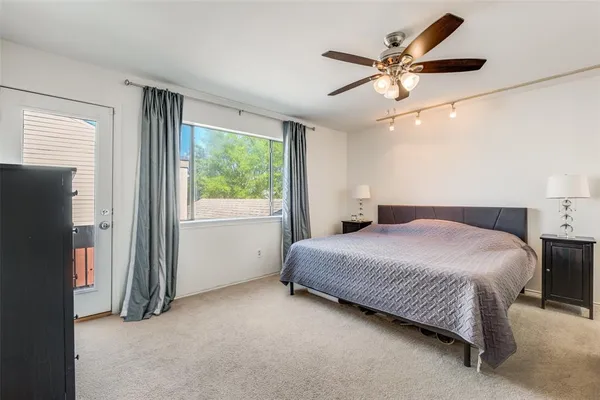 a bedroom with a large bed and a ceiling fan