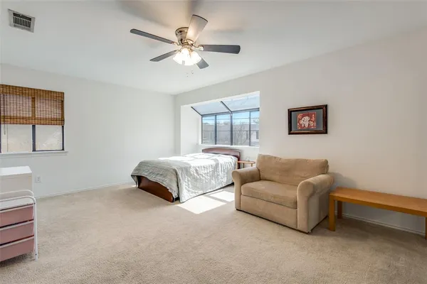 a bedroom with a bed couches and window