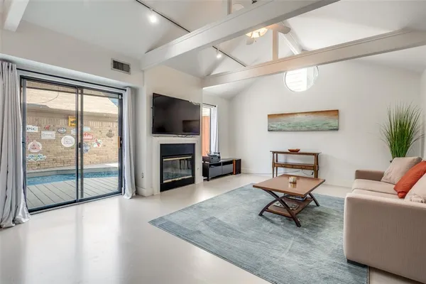 a living room with furniture a flat screen tv and a floor to ceiling window