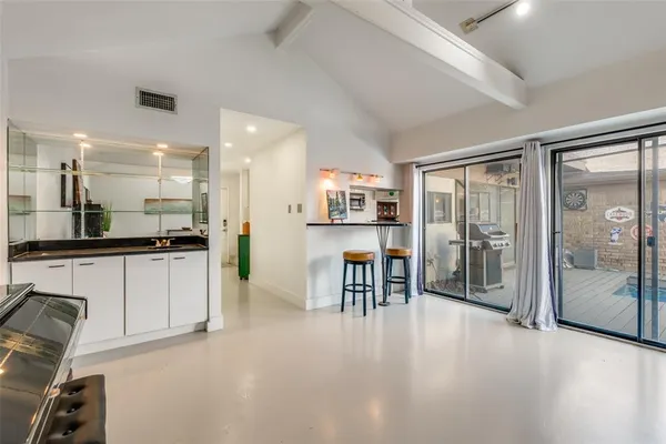 a large white kitchen with granite countertop a large window and stainless steel appliances
