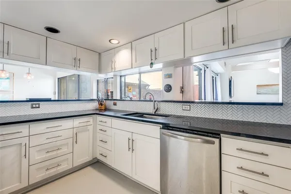 a kitchen with granite countertop white cabinets and white appliances