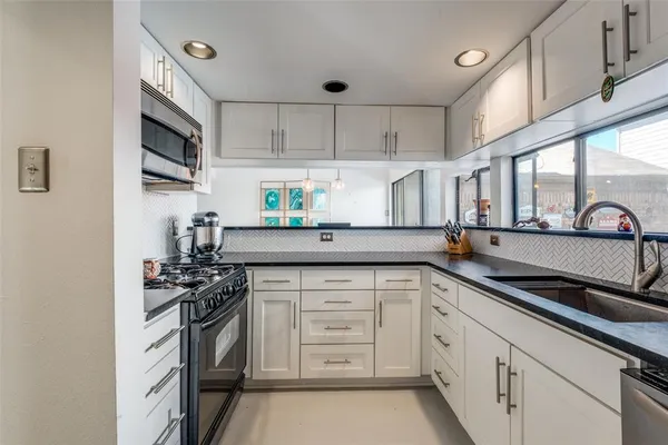 a kitchen with stainless steel appliances a sink stove and cabinets