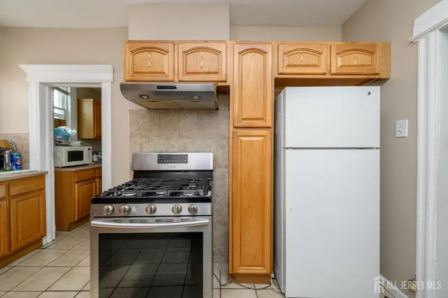 a kitchen with stainless steel appliances granite countertop a refrigerator and a stove