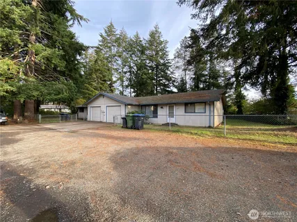 a front view of a house with a yard and trees