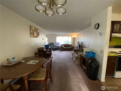 a view of a dining room with furniture a chandelier and wooden floor