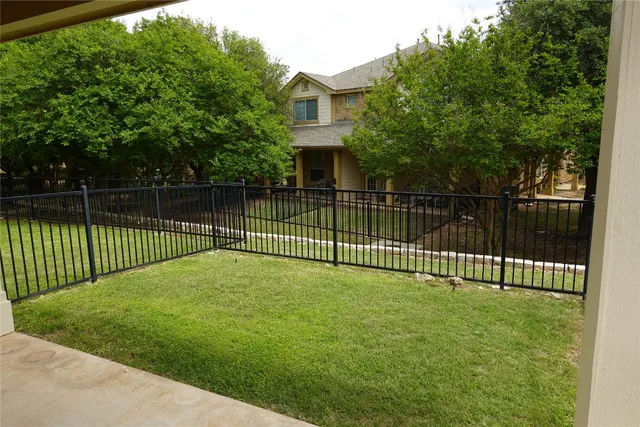 a view of a brick house and a fence yard