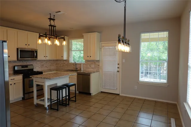 a kitchen with kitchen island granite countertop a stove a sink and a refrigerator