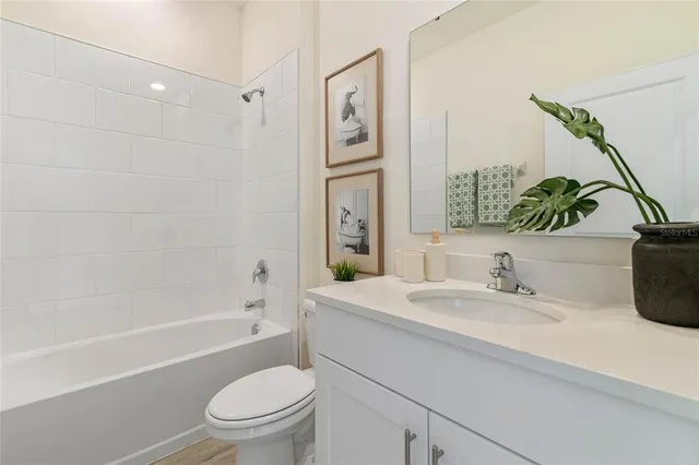 a bathroom with a granite countertop sink a toilet a mirror a vanity a bath tub and shower